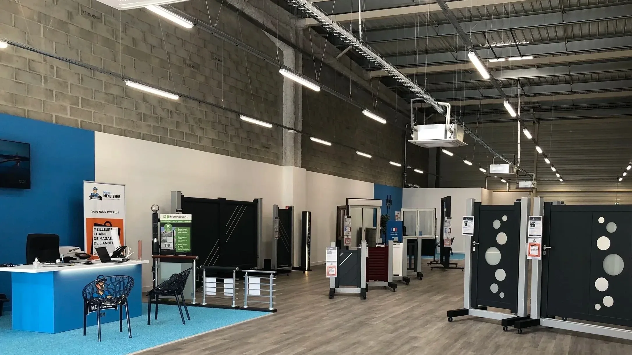 Accueil clients et présentoirs de portails dans le showroom Mister Menuiserie