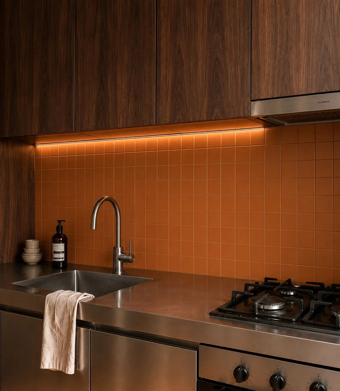 Cuisine en noyer foncé et inox, avec la crédence d’origine en carreaux terracotta — appartement haussmannien à Paris 16e
